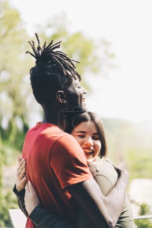 Photo for Strong bond of friendship between an African man with braided hair and a caucasian woman as they share a warm and affectionate embrace. Representing diversity and inclusivity - lifestyle concept - Royalty Free Image