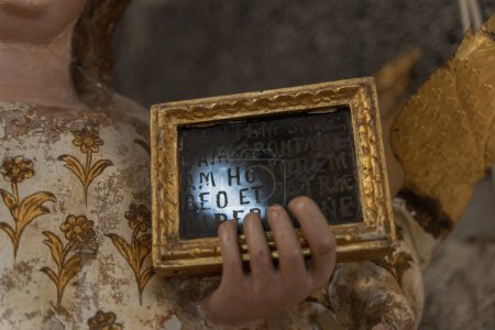 Téléchargez les photos : A close-up of the hand of the statue of Saint Agatha, a Christian martyr, holding a tablet with the inscription "AGATA VIRGO ET MARTYR" (Agatha, virgin and martyr) in Latin - en image libre de droit
