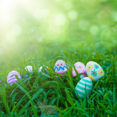 Foto de Colorful Easter eggs arranged on the grass with a bokeh background for customizable text. This festive image is perfect for Easter greetings or social media posts for a bright and cheerful composition - Imagen libre de derechos