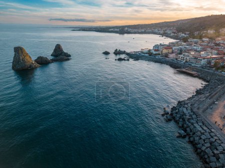 Foto de Impresionante vista aérea de las pilas de Acitrezza en la costa siciliana, capturado por un dron durante una vibrante puesta de sol. - Imagen libre de derechos