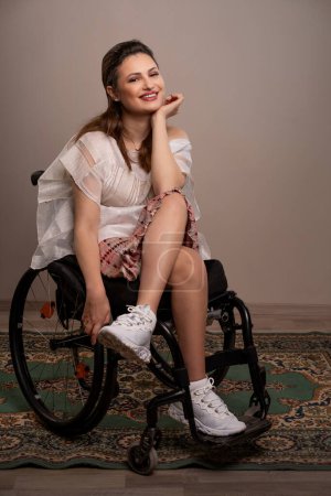 Téléchargez les photos : Une femme respire la confiance et la beauté de son fauteuil roulant, montrant son sourire rayonnant et son esprit, démontrant que la beauté ne connaît pas de frontières et que les défis ne servent qu'à l'améliorer.. - en image libre de droit