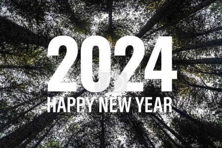 Photo for Celebratory 2024 Happy New Year message with bold white letters set against a serene backdrop of a towering tree canopy. - Royalty Free Image