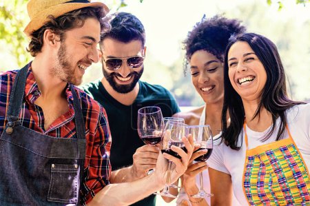 Téléchargez les photos : Amis multiraciaux griller avec du vin en plein air, profiter d'une journée ensoleillée. - en image libre de droit