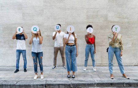 Foto de Un grupo diverso de jóvenes adultos que sostienen letras que expresan "EQUIDAD", simbolizando su apoyo a la igualdad y la inclusión en la sociedad. - Imagen libre de derechos