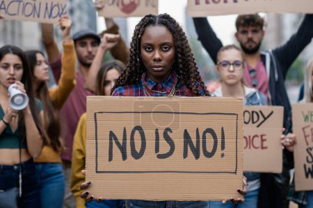Téléchargez les photos : Jeune femme tenant fermement un signe "non est non", symbolisant l'autonomisation lors d'un rassemblement féministe - en image libre de droit