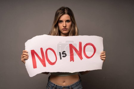 Foto de Mujer decidida sosteniendo un cartel con 'NO es NO' durante una protesta por la igualdad de género y los derechos humanos. - Imagen libre de derechos