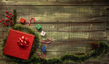 Photo for Top view of Christmas presents and seasonal decorations spread on rustic wooden surface, holiday flat lay. - Royalty Free Image
