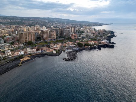 Foto de Una toma aérea que captura la esencia de la costa de Catania, destacando el paisaje urbano contra el mar Mediterráneo. - Imagen libre de derechos