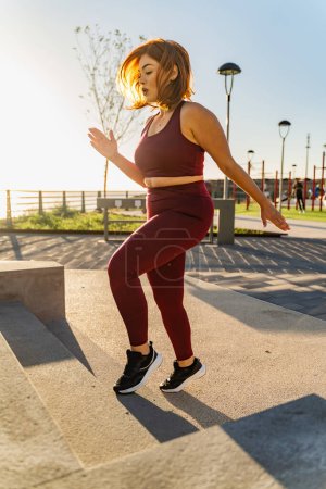 Téléchargez les photos : Un passionné de fitness fait des exercices de pas dans un parc urbain, incarnant un mode de vie actif. - en image libre de droit