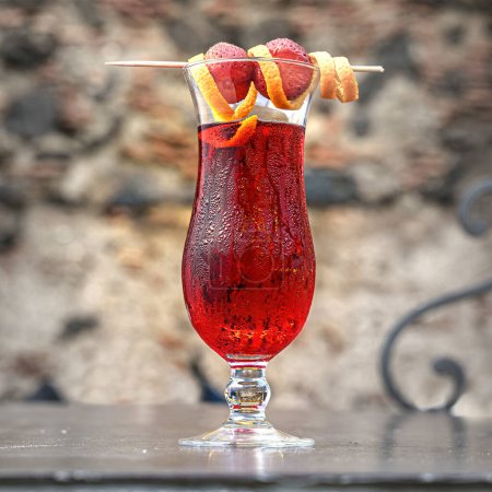 Téléchargez les photos : Cocktail rouge vibrant orné de tranches d'agrumes, servi frais, capturant l'essence du rafraîchissement d'été. - en image libre de droit