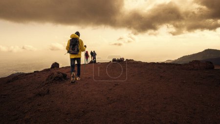 Téléchargez les photos : Randonneurs trekking à travers le terrain volcanique de l'Etna - Aventure et exploration dans le paysage dramatique sicilien. - en image libre de droit