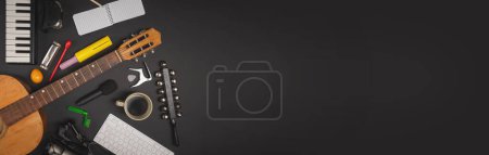 Photo for Assorted musical instruments and recording gadgets on a dark background - Music production and composition concept - flat lay view. - Royalty Free Image