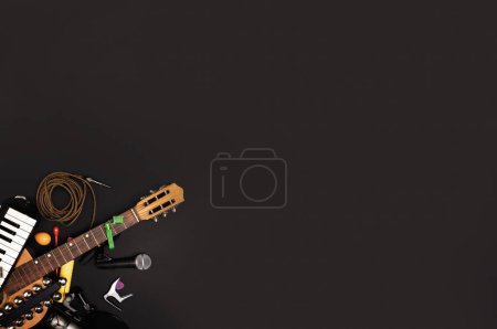 Photo for Musician's workspace with various instruments and recording accessories on a dark surface - Creative process and music arrangement concept - flat lay background for banner and ads. - Royalty Free Image