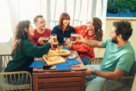 Téléchargez les photos : Groupe d'amis joyeux trinquer avec des verres de bière lors d'une fête à la maison décontractée - concept de plaisir et d'amitié - en image libre de droit