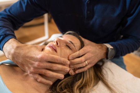 Ostéopathe effectuant un ajustement crânien délicat - Technique pour soulager la tension et améliorer la relaxation.
