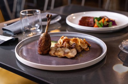 Confit de canard élégant avec garniture dans une assiette élégante - Expérience gastronomique.