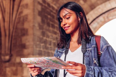 Téléchargez les photos : Jeune femme regardant une carte, en vacances de voyage d'aventure. Fille touristique latine. - en image libre de droit