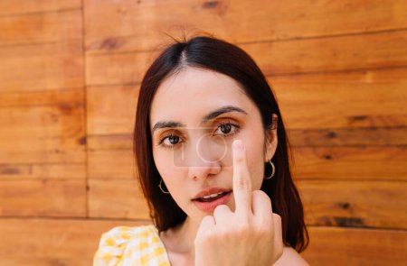 Photo for Close-up portrait of a rude girl shows index finger to camera - Royalty Free Image