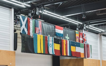 Téléchargez les photos : Dix-huit drapeaux de différents pays sont accrochés au mur sous le plafond de la salle de gym lors d'un tournoi international aux Pays-Bas. - en image libre de droit