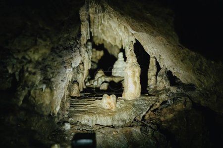 Belle vue sur les petites et grandes stalactites naturelles dans une sombre grotte souterraine de Duinen De Haan, Belgique, vue de côté gros plan.