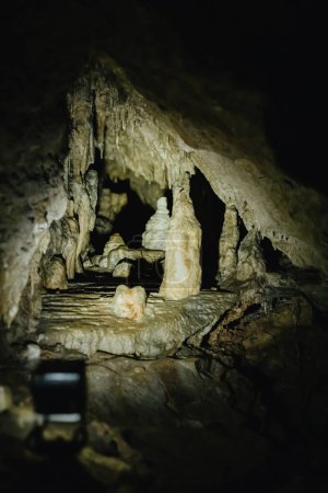 Schöne Seitenansicht von natürlichen komplizierten kleinen Stalaktiten in einer dunklen unterirdischen Höhle in De Haan, Belgien.