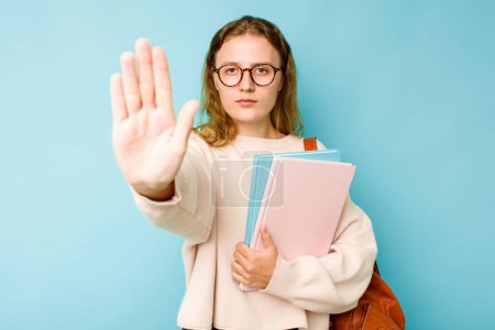 Téléchargez les photos : Jeune étudiante caucasienne isolée sur fond bleu debout avec la main tendue montrant stop signe, vous empêchant. - en image libre de droit
