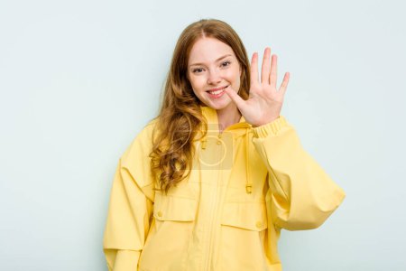 Téléchargez les photos : Jeune femme caucasienne isolée sur fond bleu souriant gai montrant numéro cinq avec les doigts. - en image libre de droit