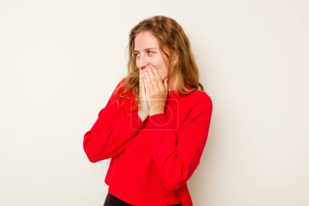 Foto de Mujer joven caucásica aislada sobre fondo blanco riendo de algo, cubriendo la boca con las manos. - Imagen libre de derechos