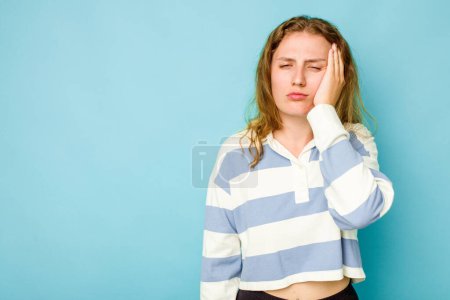 Téléchargez les photos : Jeune femme caucasienne isolée sur fond bleu qui se sent triste et onéreuse, regardant l'espace de copie. - en image libre de droit