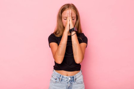 Foto de Caucásico adolescente chica aislado en rosa fondo cogido de la mano en orar cerca de la boca, se siente seguro. - Imagen libre de derechos
