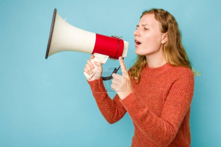 Photo for Young caucasian woman holding megaphone isolated on blue background - Royalty Free Image