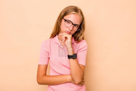 Photo for Caucasian teen girl isolated on beige background tired of a repetitive task. - Royalty Free Image