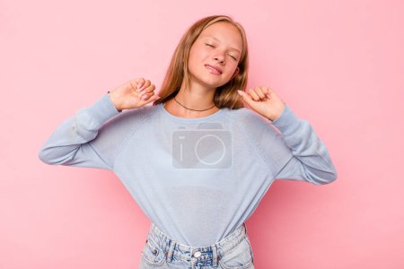 Foto de Caucásico adolescente chica aislado en rosa fondo estiramiento brazos, posición relajada. - Imagen libre de derechos