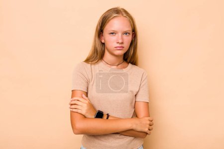 Photo for Caucasian teen girl isolated on beige background suspicious, uncertain, examining you. - Royalty Free Image