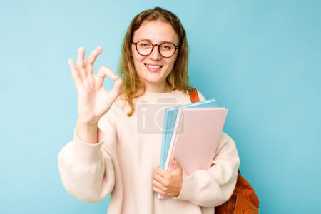 Photo for Young student caucasian woman isolated on blue background cheerful and confident showing ok gesture. - Royalty Free Image