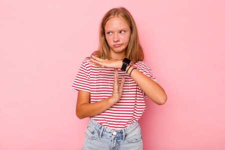 Foto de Caucásico adolescente chica aislado en rosa fondo mostrando un tiempo de espera gesto. - Imagen libre de derechos