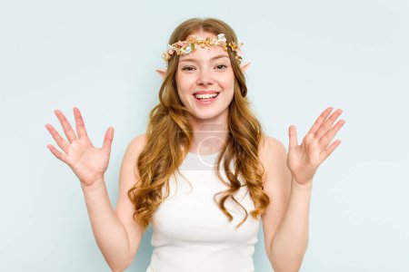 Photo for Young elf woman isolated on blue background receiving a pleasant surprise, excited and raising hands. - Royalty Free Image