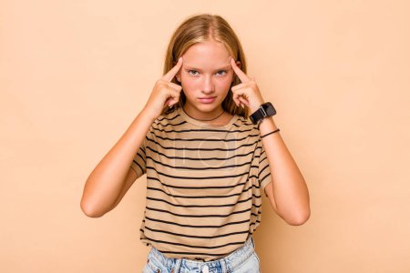 Téléchargez les photos : Caucasien adolescent fille isolé sur fond beige concentré sur une tâche, en gardant les index pointant la tête. - en image libre de droit