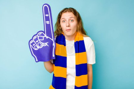 Téléchargez les photos : Jeune fan de sport caucasien femme isolée sur fond bleu haussant les épaules et les yeux ouverts confus. - en image libre de droit