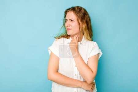 Jeune femme caucasienne isolée sur fond bleu souffre de douleur à la gorge due à un virus ou une infection.