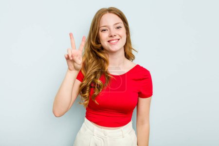 Photo for Young caucasian woman isolated on blue background joyful and carefree showing a peace symbol with fingers. - Royalty Free Image