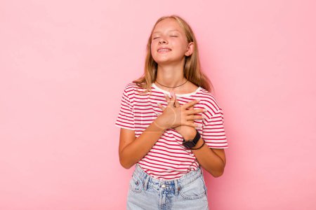Photo for Caucasian teen girl isolated on pink background has friendly expression, pressing palm to chest. Love concept. - Royalty Free Image