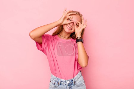 Foto de Caucásico adolescente chica aislado en rosa fondo mostrando bien signo sobre los ojos - Imagen libre de derechos