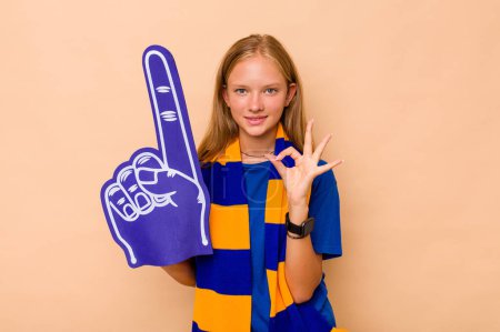 Photo for Little caucasian sports fan girl isolated on beige background cheerful and confident showing ok gesture. - Royalty Free Image