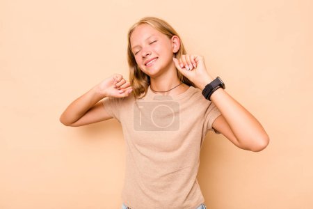 Téléchargez les photos : Caucasienne adolescent fille isolé sur fond beige célébrer un jour spécial, saute et lever les bras avec énergie. - en image libre de droit