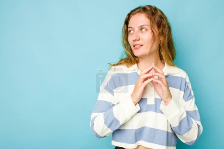 Téléchargez les photos : Jeune femme caucasienne isolée sur fond bleu faisant plan à l'esprit, la mise en place d'une idée. - en image libre de droit