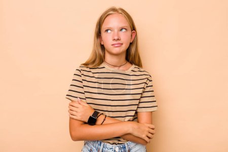 Téléchargez les photos : Caucasien adolescent fille isolé sur beige fond rêvant d'atteindre des objectifs et des buts - en image libre de droit