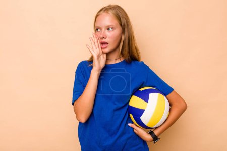 Téléchargez les photos : Petite fille caucasienne jouant au volley isolé sur fond beige criant et tenant la paume près de la bouche ouverte. - en image libre de droit
