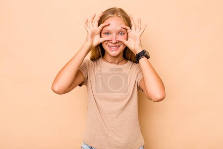 Photo for Caucasian teen girl isolated on beige background keeping eyes opened to find a success opportunity. - Royalty Free Image