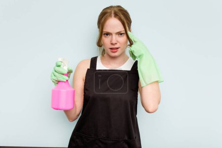 Photo for Young cleaner woman isolated on blue background showing a disappointment gesture with forefinger. - Royalty Free Image